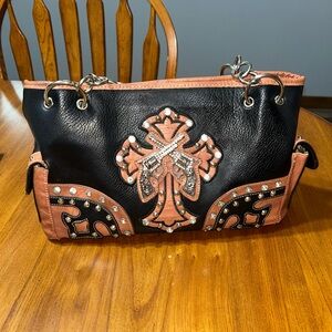 Pistol studded brown and black purse with a cross.